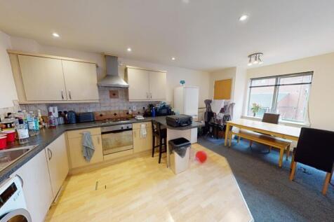 A bright and modern kitchen featuring light woo...