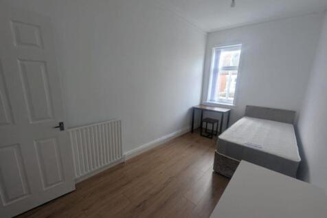 This spacious double bedroom features a comfort...