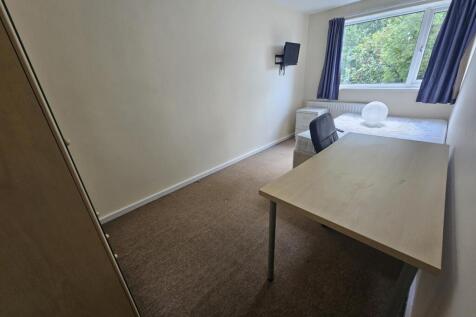 A well-lit, clean room featuring a large window...