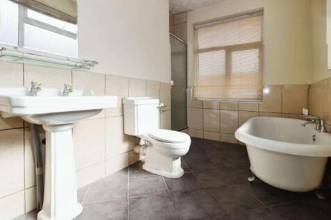 This spacious bathroom suite features a stylish...