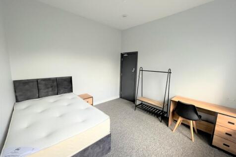A spacious and well-lit double bedroom, perfect...