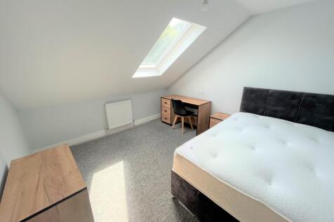 A spacious and bright double bedroom with moder...