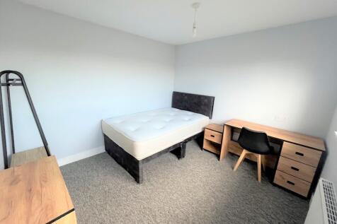 A spacious and tidy double bedroom featuring mo...
