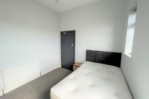 A spacious and bright double bedroom featuring ...
