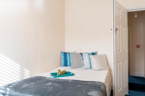 This inviting double bedroom features a cozy la...