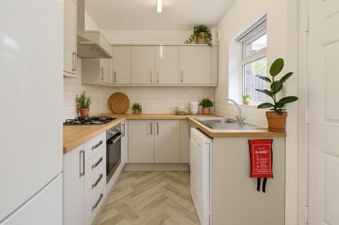 Bright and modern kitchen with sleek white cabi...