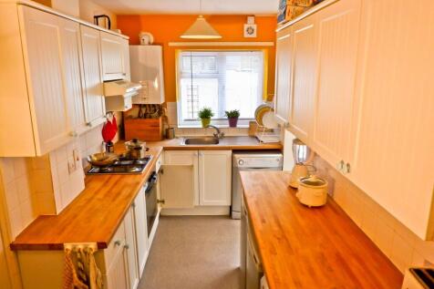 A bright and modern kitchen featuring ample cou...