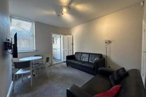 A comfortable living room featuring two black l...