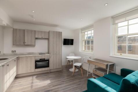 A modern and bright kitchenette featuring styli...