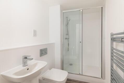 A modern and pristine bathroom featuring a slee...