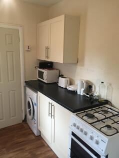 Compact and neat kitchen featuring essential ap...