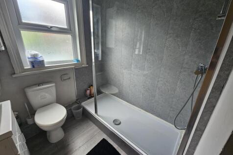 A modern, clean bathroom with a large shower ar...