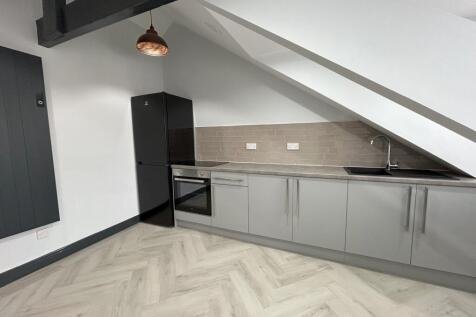 A modern kitchen with sleek grey cabinets, buil...