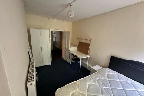 A spacious and tidy double bedroom featuring a ...
