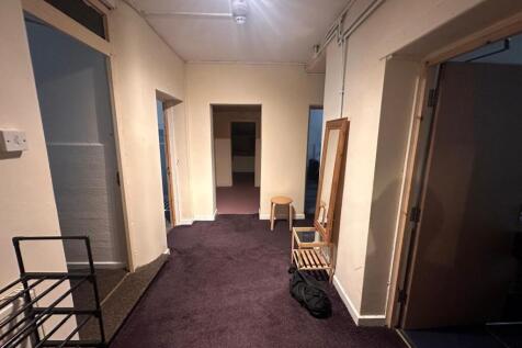 Wide internal hallway with deep-purple carpet, ...