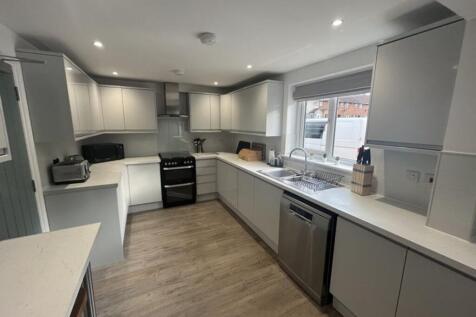 Modern and spacious kitchen featuring sleek cab...