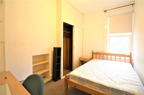 A simple, well-lit single bedroom featuring a w...
