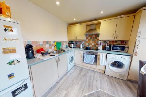 Bright, modern kitchen with ample storage and i...