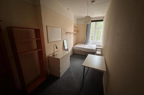 Bright single bedroom with a window at the far ...