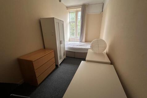 Neat, simply furnished bedroom with a double-he...