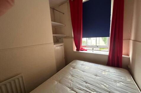 Compact bedroom with a well-presented mattress,...