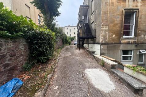 Narrow private driveway beside a period buildin...