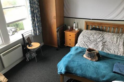 This cozy double bedroom features a comfortable...