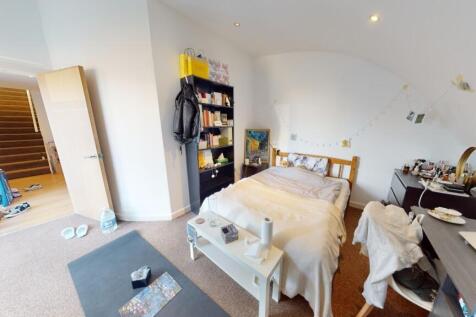 A spacious, bright master bedroom featuring a c...