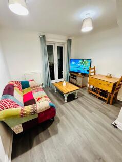 A cozy living room with a colorful sofa, ample ...