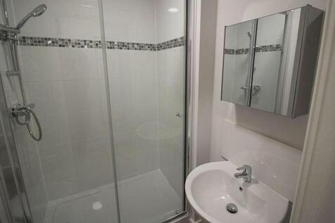 A modern bathroom featuring a sleek shower with...