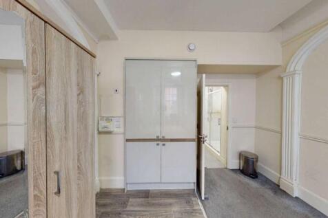 A tidy hallway featuring a modern white storage...