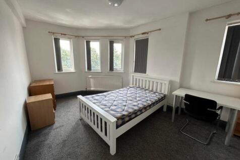 A spacious and well-lit double bedroom with mod...