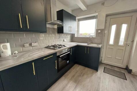 A modern and tidy kitchenette with ample storag...