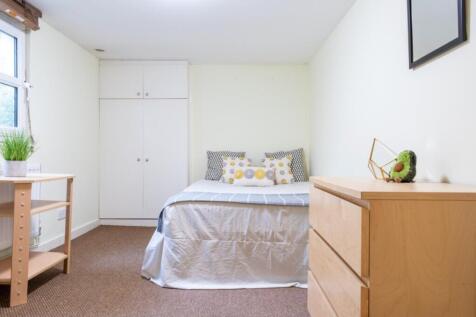 This inviting double bedroom features a cozy at...