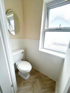 A bright and tidy single toilet featuring a mod...