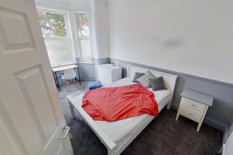 A clean and simple single toilet room with whit...