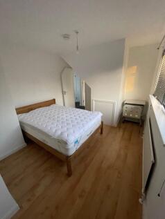 A neat double bedroom featuring a comfortable w...