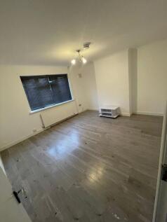 A spacious living room with clean, light wood f...