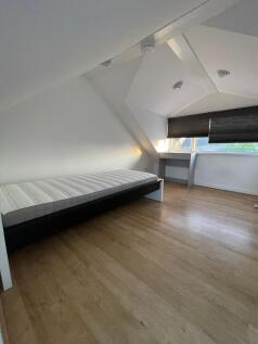 A neat and minimal single bedroom featuring a c...