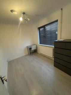 A minimalist single bedroom featuring light woo...