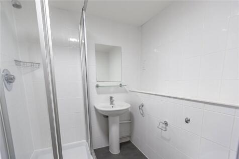 A clean and bright bathroom featuring a walk-in...