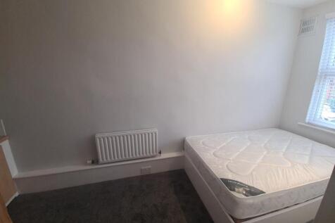 A neat and simple bedroom featuring a comfortab...
