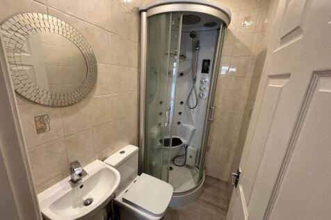 A modern bathroom featuring a sleek shower unit...