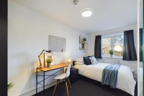 A bright and cozy bedroom featuring a comfortab...