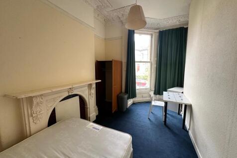 A spacious and inviting double bedroom with nat...