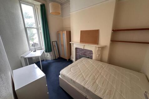 Bright furnished bedroom with a large sash wind...