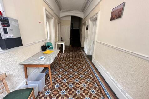 A spacious and well-maintained hallway with bea...