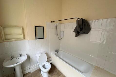 A functional bathroom featuring a bath and show...
