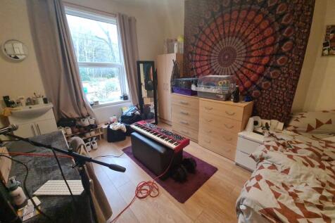 A cozy and personalized single bedroom featurin...