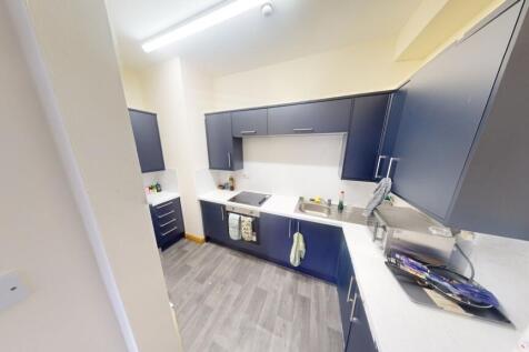 A modern kitchen with dark blue cabinetry and w...